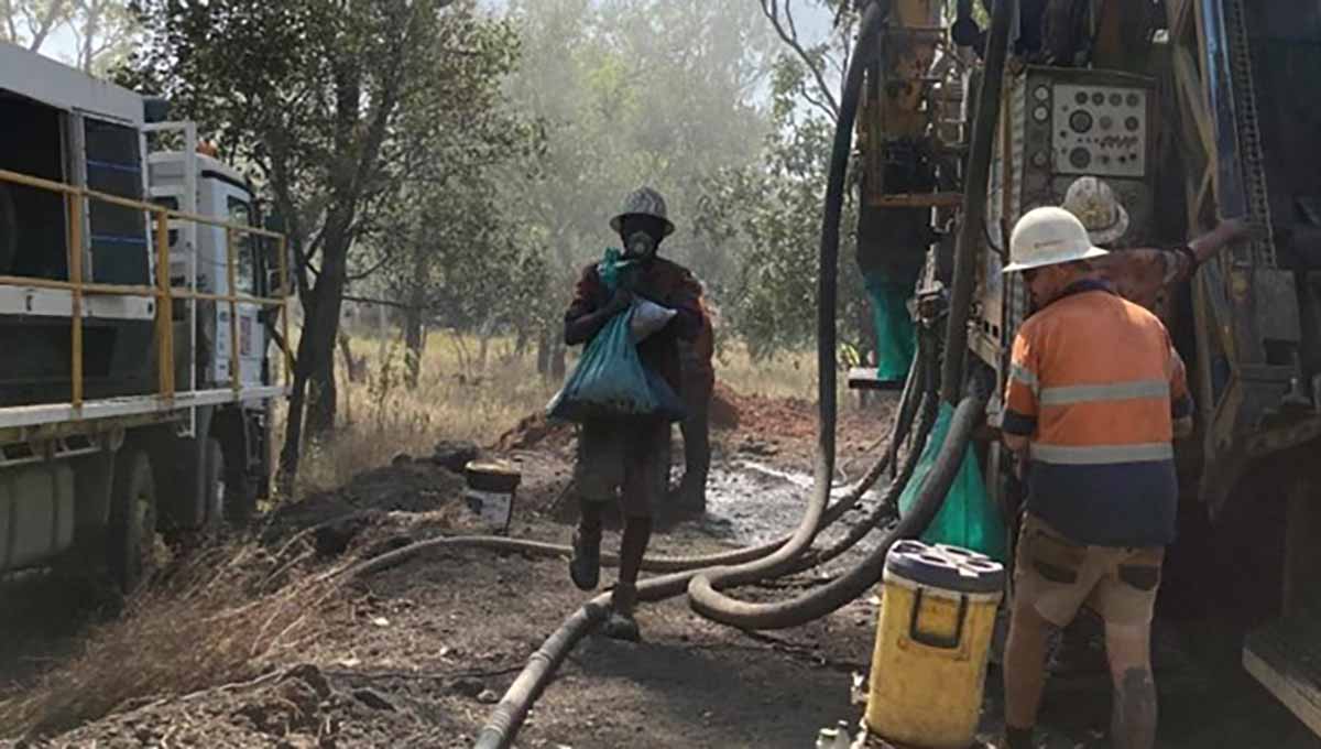 Two men operate the drill rig at Kingsland's Leliyn project.